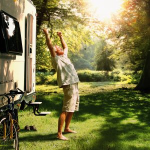 Man stretching outside his campervan